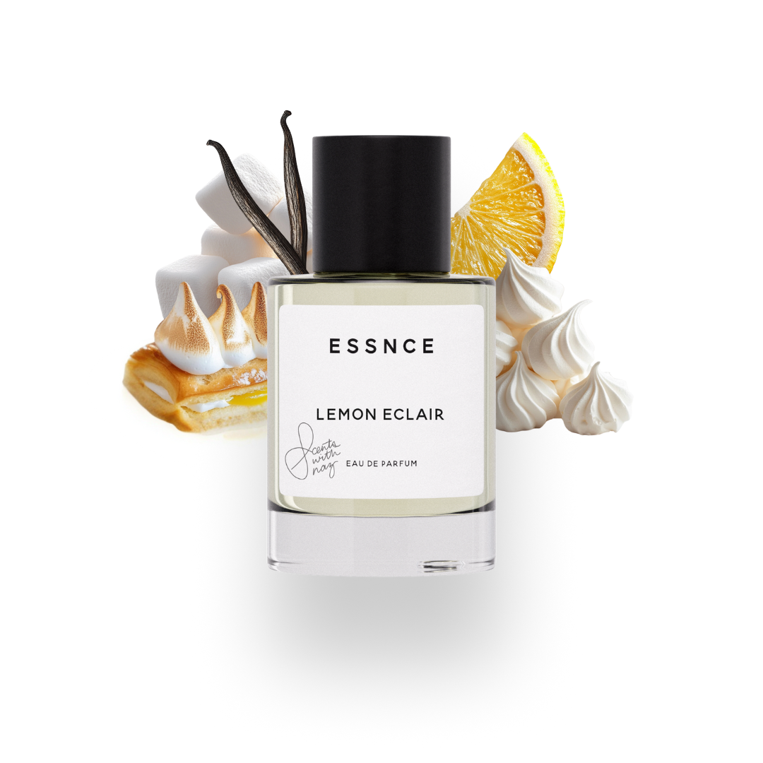 En flaska ESSNCE Originals Creator  Lemon Eclair gjord tillsammans med Scents with Naz visas med en svart kork och en vit etikett. Bakom flaskan finns ingredienser som lemon eclair, marshmallow, maräng, citron och vaniljstänger.